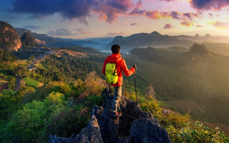 Backpacker standing on sunrise viewpoint at Ja Bo village, Mae hong son province, Thailand.